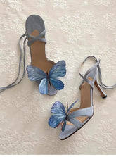 High-heeled shoes with blue butterfly decorations on a textured surface